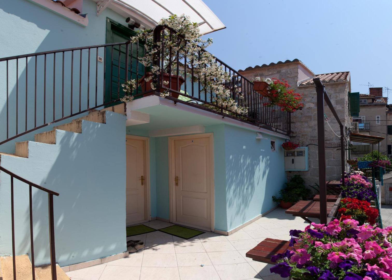 Stairs and a flower-filled terrace leading to the room doors